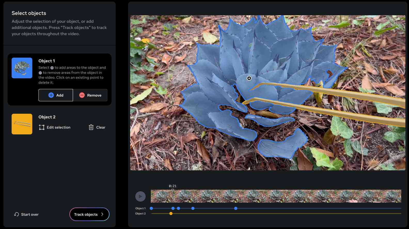 A video editing interface focused on object tracking. The main part of the screen displays a close-up photograph of a blue-gray succulent plant growing among dry leaves and forest floor debris. The plant is outlined in blue, indicating it has been selected as "Object 1" for tracking. On the left side of the interface, there are controls for selecting and editing objects. Two objects are listed: Object 1 (the succulent plant) and Object 2 (likely the yellow stem visible in the image). At the bottom of the screen is a video timeline showing thumbnail frames, with blue and yellow lines representing the tracked paths of Objects 1 and 2 respectively. The interface includes options to add or remove areas from the selected object, start over, and "Track objects" to follow the selected items throughout the video.