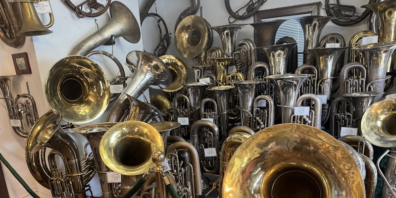 More than a dozen varied and beautiful tubas, each with a neat attached label.