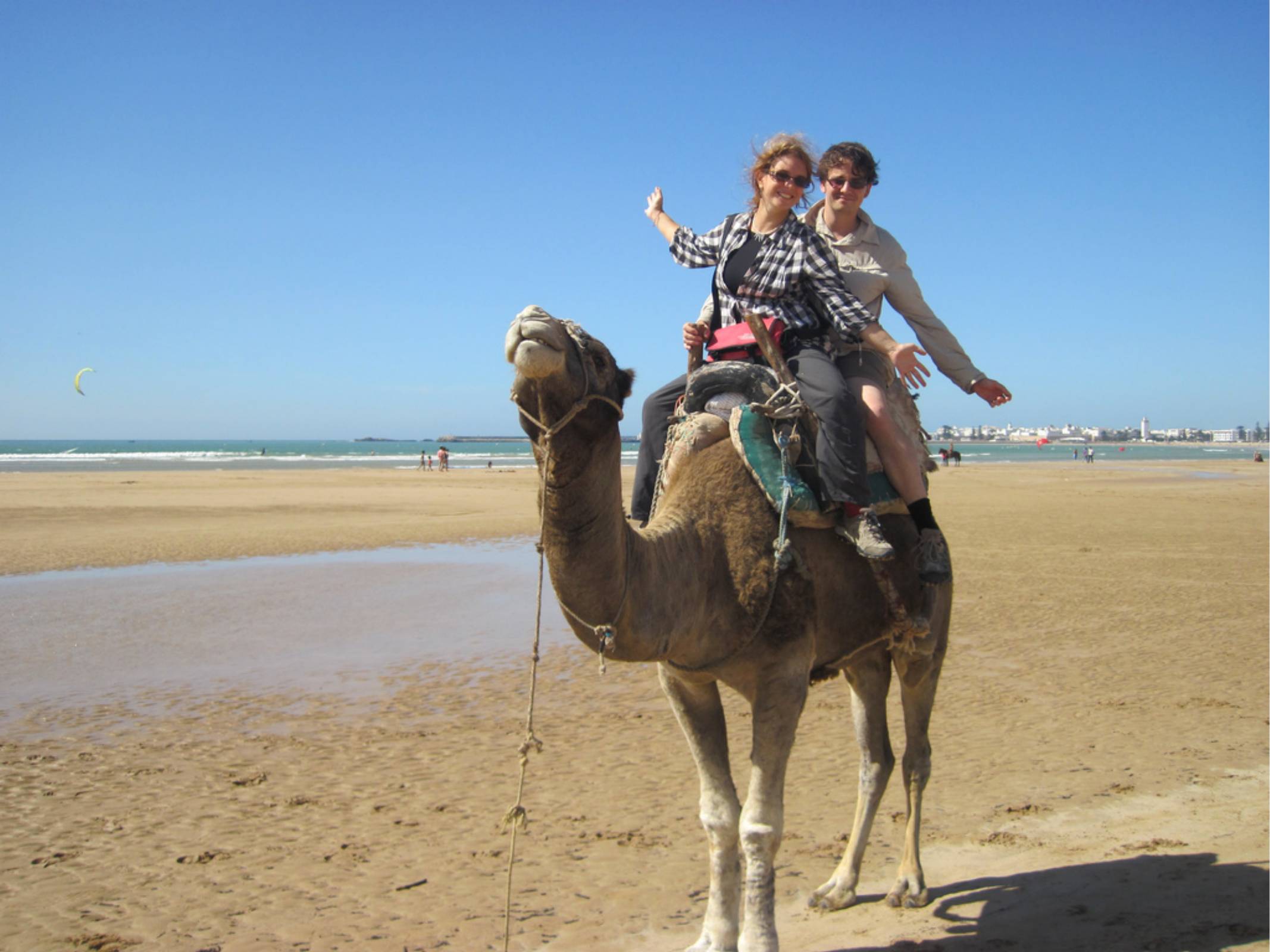 Natalie and I riding a camel on a beach