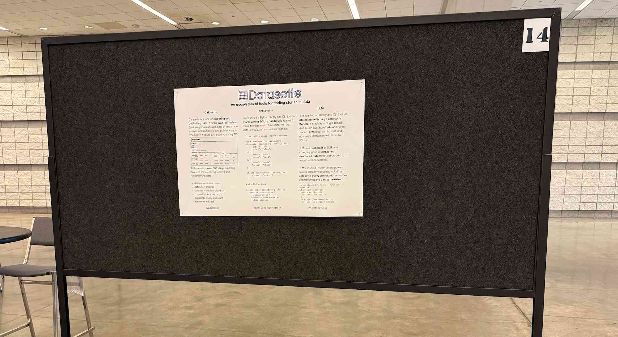 My Datasette poster on a huge black poster board. It looks a bit lonely in the middle surrounded by empty space.